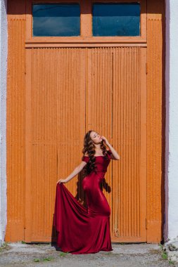 Eski kapı yanındaki bir tren konumu olan bir uzun kırmızı gece elbisesi güzel genç kadın