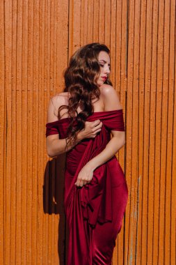 Eski kapı yanındaki bir tren konumu olan bir uzun kırmızı gece elbisesi güzel genç kadın
