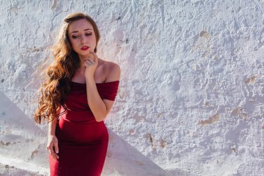 Uzun kırmızı gece elbisesi ayakta duvar eski yanında güzel ve genç birbayan. Kopya alanı.