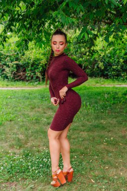 Kiraz elinde tutan uzun örgü ve kiraz küpe olan güzel kadın