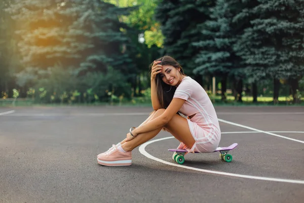 Портрет Улыбающейся Очаровательной Брюнетки Сидящей Скейтборде Баскетбольной Площадке Счастливая Женщина — стоковое фото