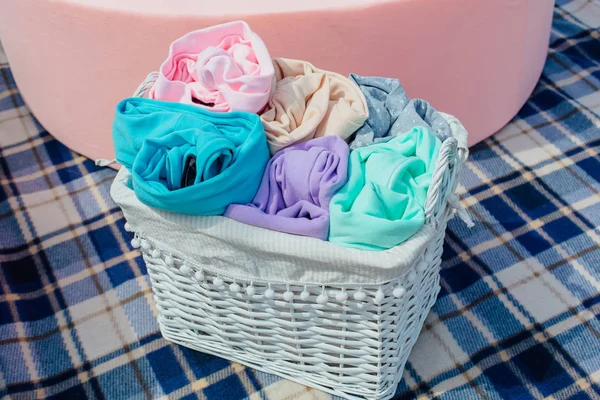 Colorful pastel clothes in a wicker basket