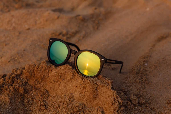 Sluneční Brýle Ležet Písku Odrazem Zapadajícího Slunce — Stock fotografie