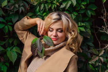 Yabani üzüm sonbahar park yüzüne yakın tutarak bırakır arka yanındaki genç güzel kadın kazak ve ceket durumda