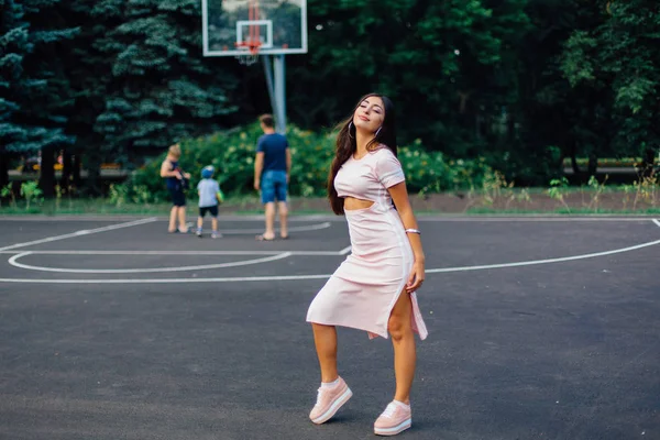 Mulher Morena Encantadora Vestida Com Vestido Rosa Posando Quadra Basquete — Fotografia de Stock