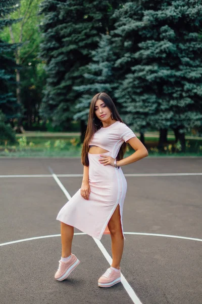 Encantadora Morena Vestida Con Vestido Rosa Posando Cancha Baloncesto Atardecer — Foto de Stock