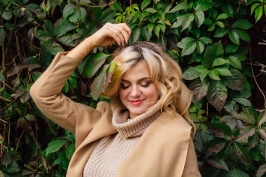 Yabani üzüm sonbahar park yüzüne yakın tutarak bırakır arka yanındaki genç güzel kadın kazak ve ceket durumda