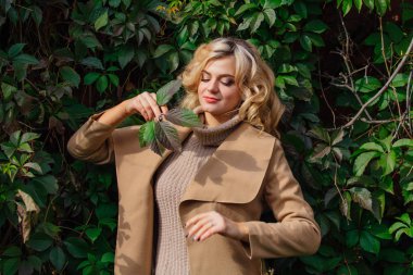 Yabani üzüm sonbahar park yüzüne yakın tutarak bırakır arka yanındaki genç güzel kadın kazak ve ceket durumda