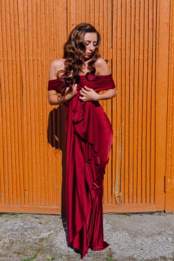 Eski kapı yanındaki bir tren konumu olan bir uzun kırmızı gece elbisesi güzel genç kadın