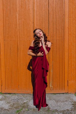 Eski kapı yanındaki bir tren konumu olan bir uzun kırmızı gece elbisesi güzel genç kadın