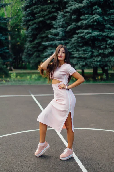 Encantadora Morena Vestida Con Vestido Rosa Posando Cancha Baloncesto Atardecer — Foto de Stock