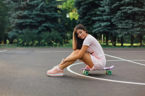 Retrato Una Encantadora Morena Sonriente Sentada Monopatín Una Cancha Baloncesto —  Fotos de Stock