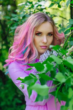 Renkli boyalı saç ve mükemmel makyaj standig leylak bush yanındaki ile güzel kız