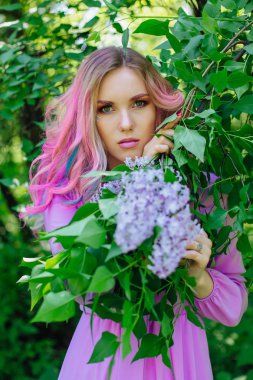 Renkli boyalı saç ve mükemmel makyaj standig leylak bush yanındaki ile güzel kız