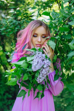 Renkli boyalı saç ve mükemmel makyaj standig leylak bush yanındaki ile güzel kız