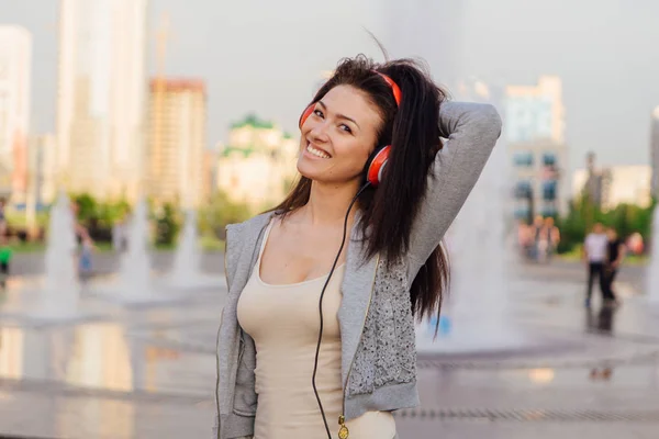Молодая женщина слушает музыку в наушниках . — стоковое фото