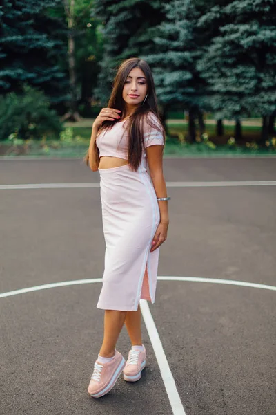 Encantadora Morena Vestida Con Vestido Rosa Posando Cancha Baloncesto Atardecer — Foto de Stock