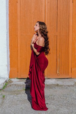 Eski kapı yanındaki bir tren konumu olan bir uzun kırmızı gece elbisesi güzel genç kadın