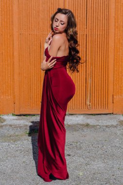 Eski kapı yanındaki bir tren konumu olan bir uzun kırmızı gece elbisesi güzel genç kadın