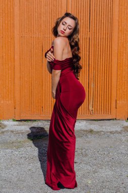 Eski kapı yanındaki bir tren konumu olan bir uzun kırmızı gece elbisesi güzel genç kadın