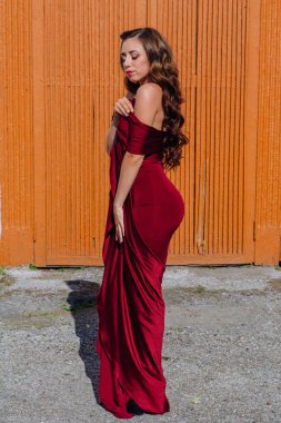 Eski kapı yanındaki bir tren konumu olan bir uzun kırmızı gece elbisesi güzel genç kadın