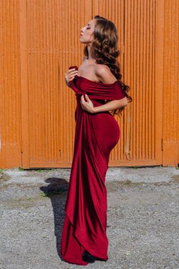 Eski kapı yanındaki bir tren konumu olan bir uzun kırmızı gece elbisesi güzel genç kadın