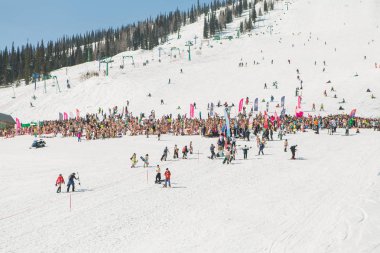 Bikini ve şort ile snowboard ve dağ kayak yamacında insanlar kalabalık