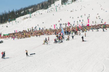 Bikini ve şort ile snowboard ve dağ kayak yamacında insanlar kalabalık