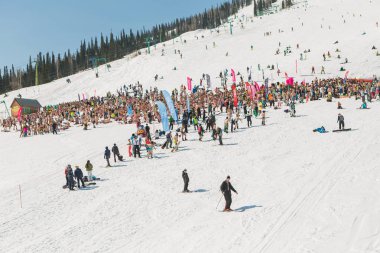 Bikini ve şort ile snowboard ve dağ kayak yamacında insanlar kalabalık