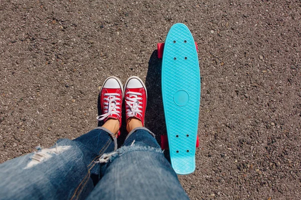 Detailní záběr nohou na modré plastové penny skateboard s růžovou koly. — Stock fotografie