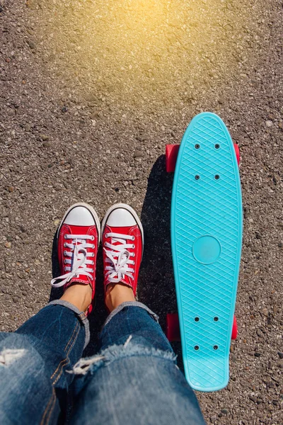 Detailní záběr nohou na modré plastové penny skateboard s růžovou koly. — Stock fotografie