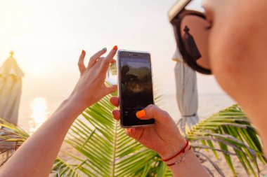 Kristal lens topu ile smartphone sahilde deniz ve gün batımı yansıması ile çekim Kadın