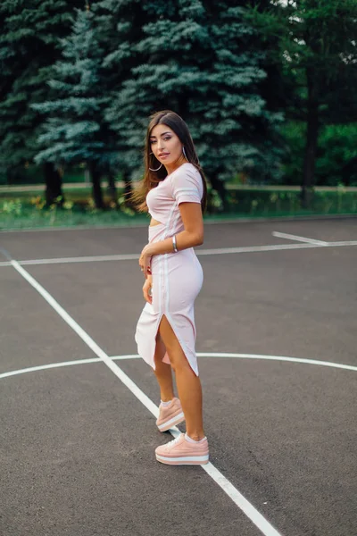 Encantadora Morena Vestida Con Vestido Rosa Posando Cancha Baloncesto Atardecer —  Fotos de Stock