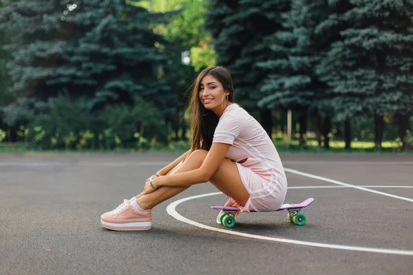 Retrato Una Encantadora Morena Sonriente Sentada Monopatín Una Cancha Baloncesto — Foto de Stock