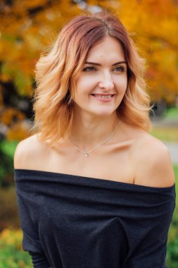 İle siyah elbiseli çekici bir kadın portresi açık omuz sonbahar rowan ağacı altında
