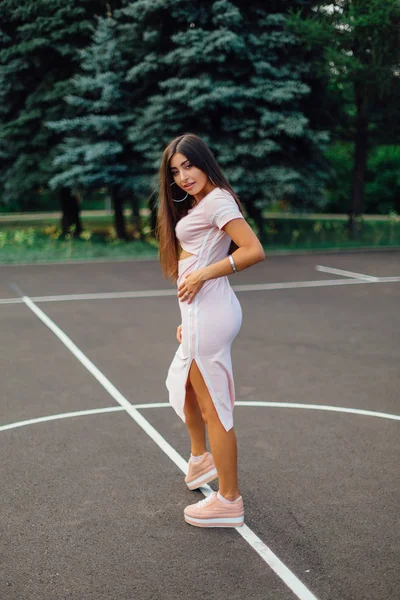 Очаровательная Брюнетка Одетая Розовое Платье Позирует Баскетбольной Площадке Время Заката — стоковое фото