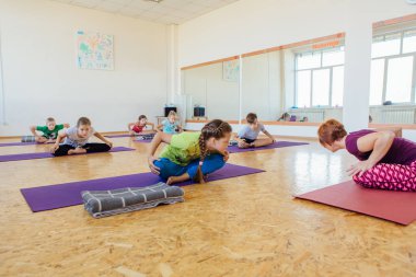 Novokuznetsk, Kemerovo bölgesi, Rusya Federasyonu - 11 Ağustos 2018: yoga sınıfına öğretmenle yoga egzersizleri yapıyor farklı yaş çocuklar.