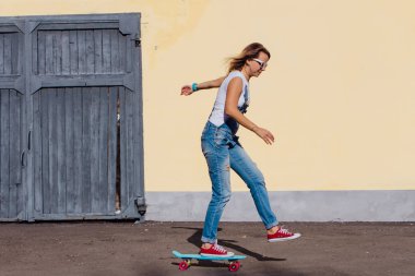 Tulum ve eski ahşap duvar yanındaki plastik onun kaykay sürme güneş gözlüğü gülümseyen bir kadın portresi giymiş.