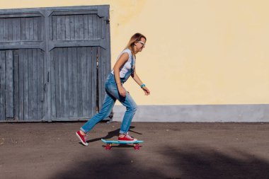 Tulum ve eski ahşap duvar yanındaki plastik onun kaykay sürme güneş gözlüğü gülümseyen bir kadın portresi giymiş.