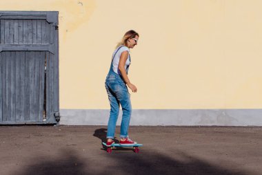 Tulum ve eski ahşap duvar yanındaki plastik onun kaykay sürme güneş gözlüğü gülümseyen bir kadın portresi giymiş.