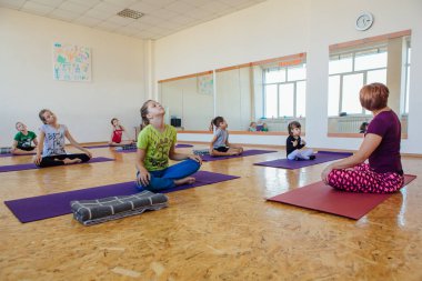 Yoga dersi öğretmeni bir odada çocuklar için