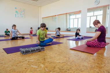 Yoga dersi öğretmeni bir odada çocuklar için