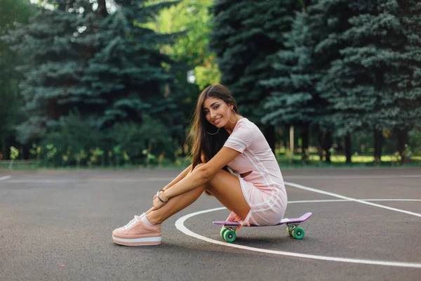 Portrait Smiling Charming Brunette Female Sitting Her Skateboard Basketball Court — Stock Photo, Image