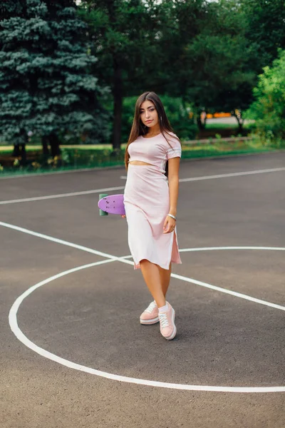 Retrato Una Encantadora Morena Sonriente Sosteniendo Mano Monopatín Una Cancha —  Fotos de Stock