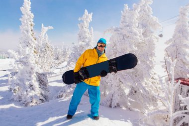 Kış orman ağaçları ile kış tatil snowboard ile genç erkek snowboard karla kaplı