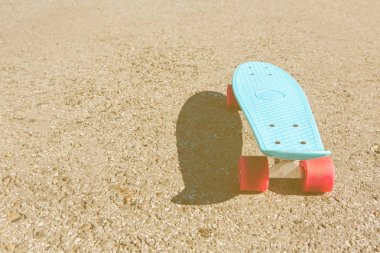 Mavi plastik kaykay kuruş pano pembe tekerlekli pistte duruyor.