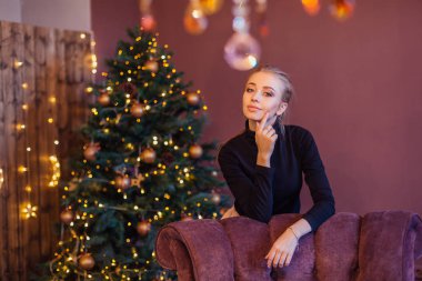 Noel ağacının yanındaki uzun sarı ayakta olan güzel kadın. Noel glamour fotoğraf