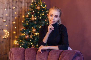 Noel ağacının yanındaki uzun sarı ayakta olan güzel kadın. Noel glamour fotoğraf
