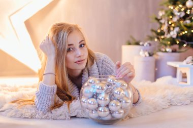 Güzel genç kadın büyük Star kase ile Noel ağacı tam bir tatil iç gümüş topları ile döşeme