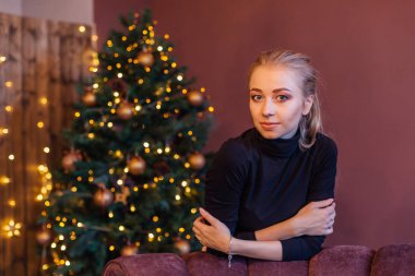 Güzel genç kadın uzun saçlı nex Noel ağacına ayakta.